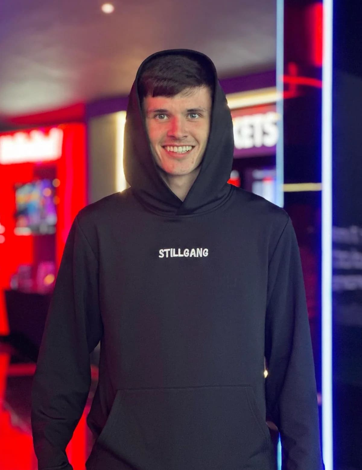 Ryan smiling in his black STILLGANG hoodie